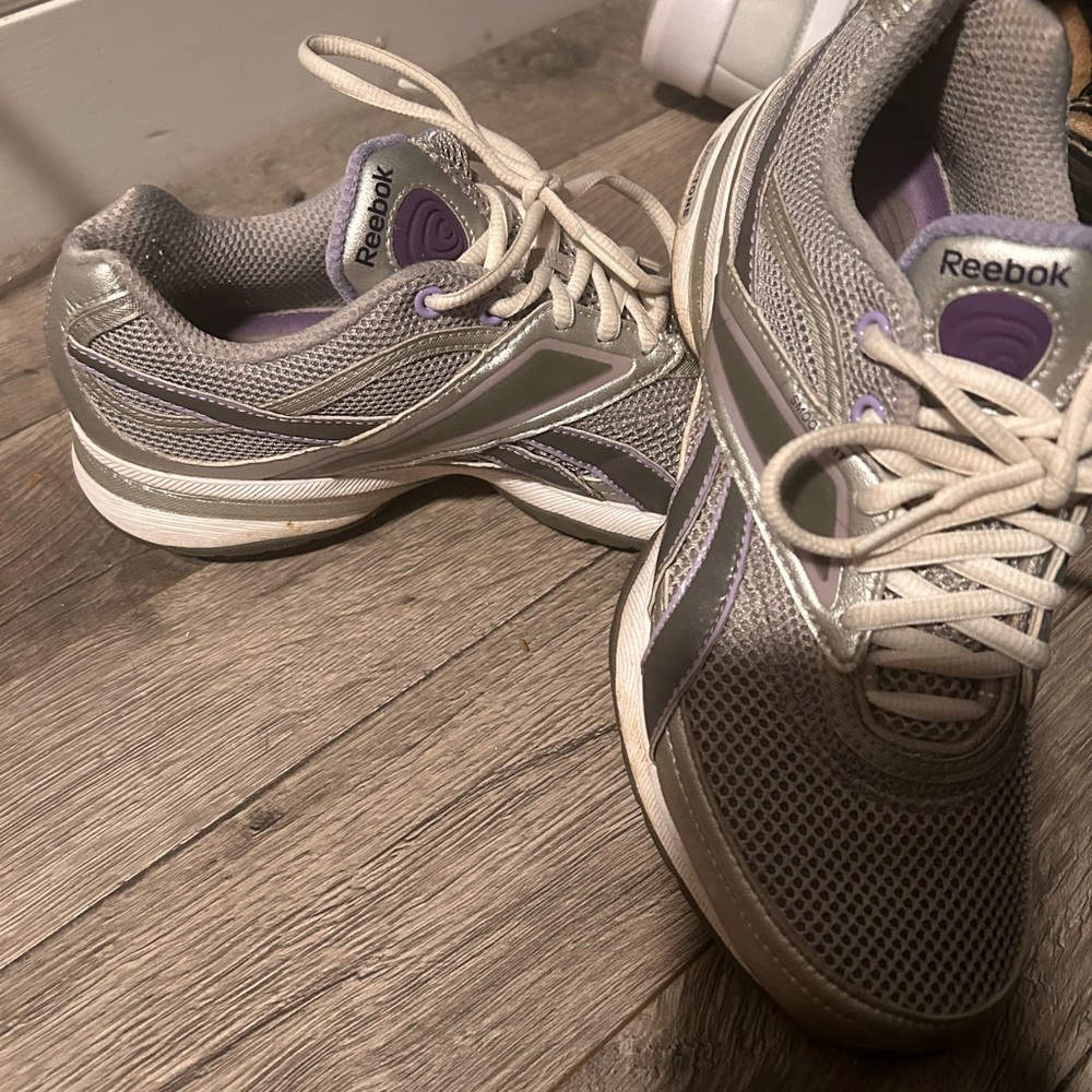 Woman’s silver and purple Reeboks